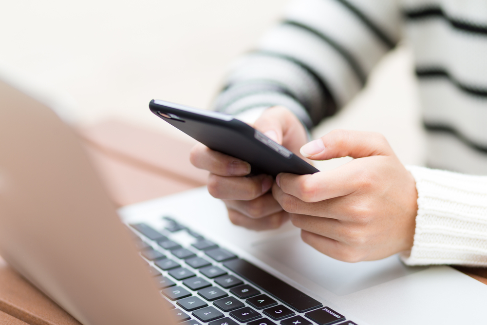 woman on phone and laptop